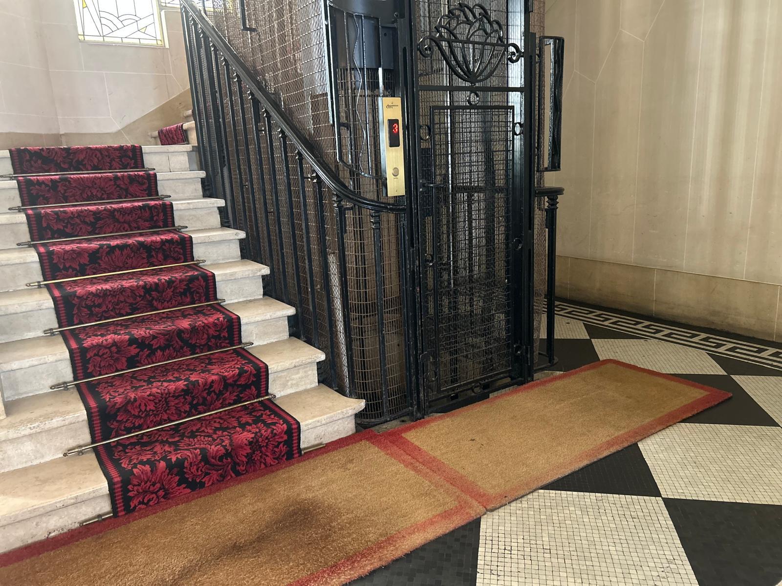 Ascenseur ancien à grille dans un immeuble parisien